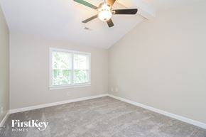 Greensboro house for rent - the bedroom of a home with carpet and a ceiling fan