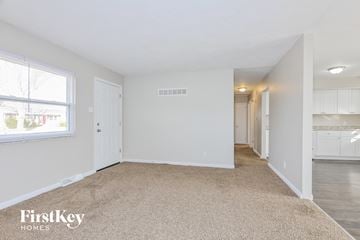 Saint Peters house for rent - a spacious living room and kitchen with white cabinets and a large window