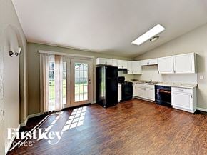 Saint Peters house for rent - an empty kitchen with white cabinets and black appliances and wood floors