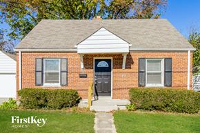 Cincinnati house for rent - A brick house with a black door and a small porch.