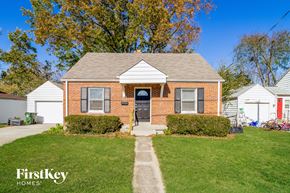 Cincinnati house for rent - A brick house with a white garage door and a red door.