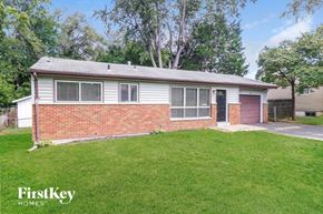 Florissant house for rent - A house with a red door and a brick wall is for sale.