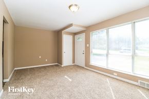Florissant house for rent - A room with a carpet floor and a window with blinds.