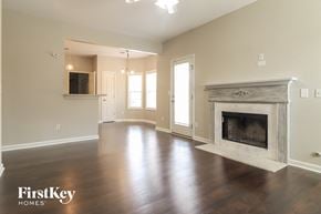 Dallas house for rent - an empty living room with a fireplace and a tv