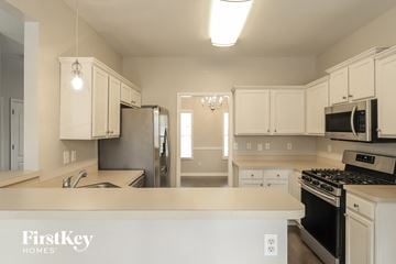 Dallas house for rent - a kitchen with white cabinets and stainless steel appliances