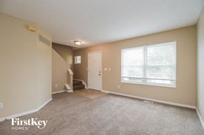 Amelia house for rent - A spacious room with a staircase leading to the second floor.