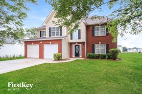 Covington house for rent - A house with a red brick exterior and a white garage door is for sale.