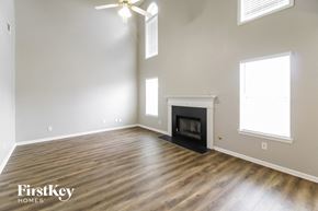 Covington house for rent - A spacious room with a fireplace and a ceiling fan.