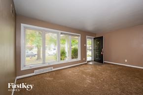 Saint Louis house for rent - the living room of a house with large windows and carpeting