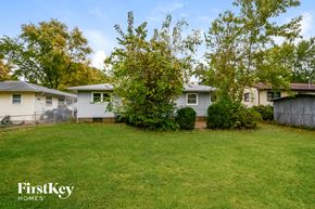 Saint Louis house for rent - a backyard with two houses and a yard with grass and trees