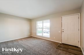 O'fallon house for rent - A room with a carpeted floor, a door, and a window.