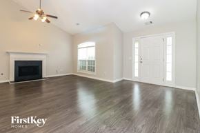 Covington house for rent - A spacious room with a fireplace and wood flooring.