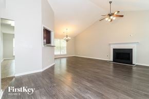Covington house for rent - A spacious living room with a fireplace and a ceiling fan.