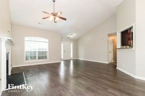 Covington house for rent - A spacious room with a ceiling fan and wooden flooring.
