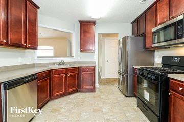 Covington house for rent - A kitchen with wooden cabinets and a tile floor.
