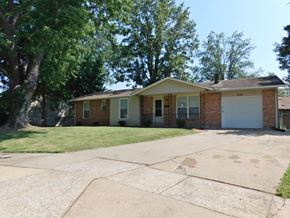 Florissant house for rent - a small brick house with a white garage door