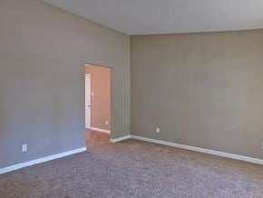 Florissant house for rent - an empty living room with carpet and a door to a hallway