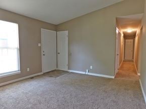 Florissant house for rent - a bedroom with a carpeted floor and a door to a hallway