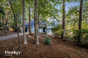 Newnan house for rent - a blue house in the woods with trees