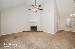 Newnan house for rent - the living room has a fireplace and a ceiling fan