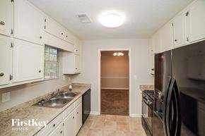 Newnan house for rent - a kitchen with stainless steel appliances and white cabinets