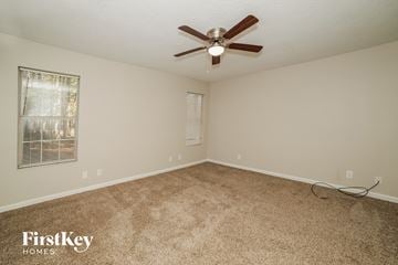 Newnan house for rent - a living room with carpet and a ceiling fan