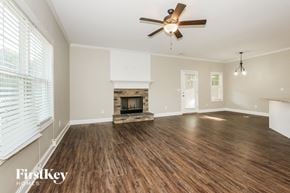 Newnan house for rent - a living room with a fireplace and a ceiling fan