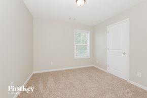 Newnan house for rent - a bedroom with a carpeted floor and a white door