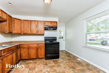 Saint Peters house for rent - A kitchen with wooden cabinets and a black oven.