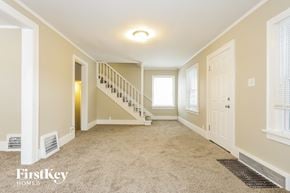 Waukegan house for rent - a empty living room with a staircase and a door to a hallway and a window