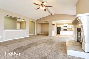 Saint Peters house for rent - A spacious living room with a ceiling fan and a carpeted floor.