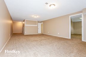 Saint Peters house for rent - A spacious room with beige carpeting and a white ceiling.