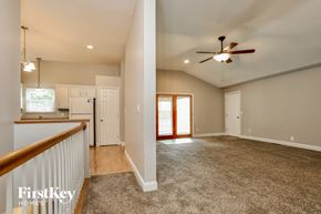 Saint Peters house for rent - a kitchen and living room with a carpeted floor and a ceiling fan