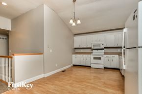 Saint Peters house for rent - an empty kitchen with white cabinets and appliances and a wooden floor