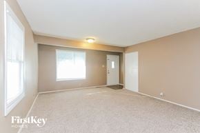 Indianapolis house for rent - A spacious room with a carpeted floor and a window letting in natural light.