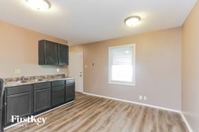 Indianapolis house for rent - A kitchen with wooden floors and a black countertop.