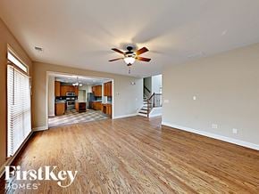 Dallas house for rent - an open living room with wood flooring and a ceiling fan