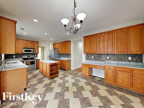 Dallas house for rent - a large kitchen with wood cabinets and granite counter tops