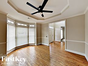 Dallas house for rent - an empty living room with wood floors and a ceiling fan