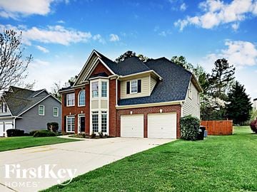 Dallas house for rent - a large brick house with a garage and a lawn
