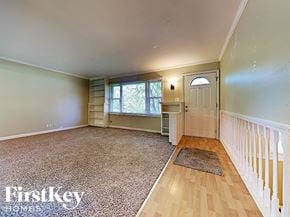West Chicago house for rent - an empty living room with a staircase and a white door