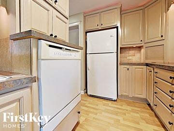 West Chicago house for rent - a kitchen with white appliances and wood flooring