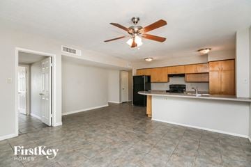Tempe house for rent - A kitchen area with a fan and a fridge.