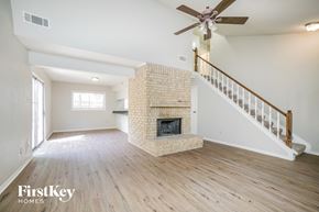 Spring house for rent - a living room with a fireplace and a ceiling fan