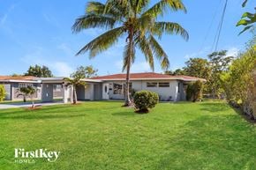 Plantation house for rent - a house with a palm tree in front of it