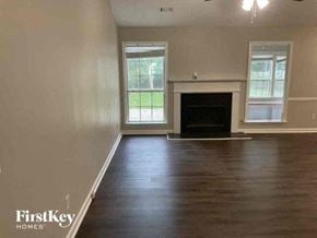 Covington house for rent - A room with a fireplace and two windows.