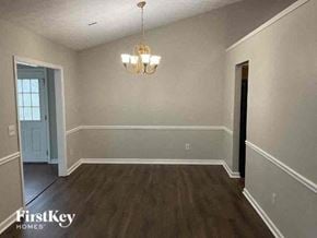 Covington house for rent - A room with wooden floors and a chandelier hanging from the ceiling.
