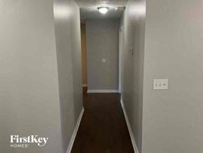 Covington house for rent - A narrow hallway with a door at the end and a light switch on the wall.