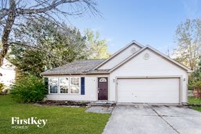 Brownsburg house for rent - A two-car garage with a brown door is situated in front of a house.