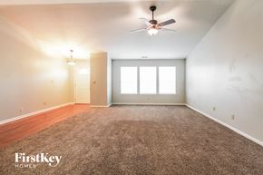Brownsburg house for rent - A spacious room with a carpeted floor and a ceiling fan.